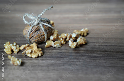 Wallpaper Mural One walnut wrapped with  twine and bow and kernel walnuts on dark walnut table background Torontodigital.ca