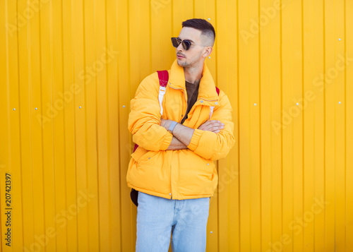 fashion guy standing near a yellow wall in yellow clothes