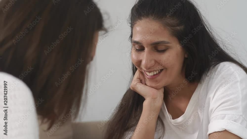 Portait of a beautiful brunette women sitting on the couch at home. Lovely woman is happy and smiling. Spending time with friends. Portait of a beautiful brunette women sitting on the couch at home. Lovely woman is happy and smiling. Spending time with friends.