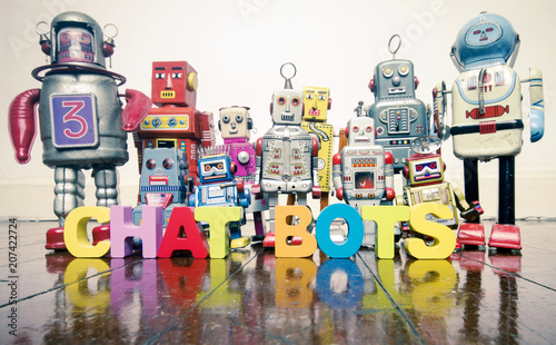 the word CHAT BOTS with wooden letters and retro toy robots on an old wooden floor
