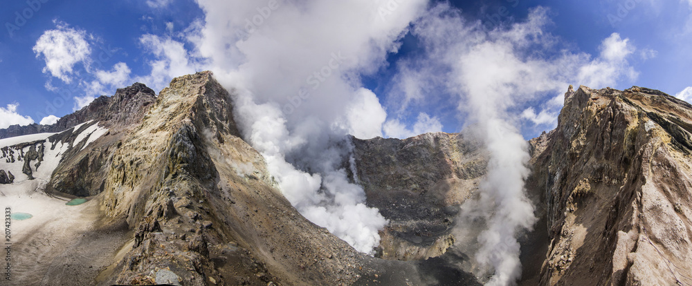 steaming crater of active volcano covered by snow