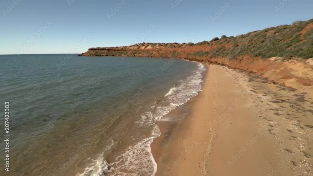 A medium shot of a shoreline and the sea with beach. Camera slowly moves backward A medium shot of a shoreline and the sea with beach. Camera slowly moves backward