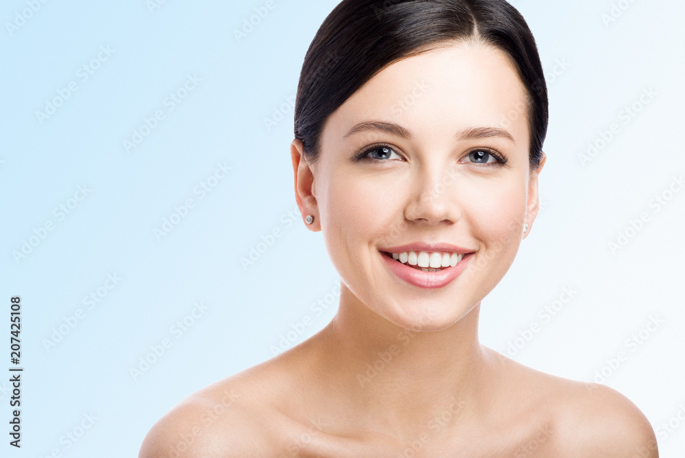 Smiling young woman on light background. Perfect clean skin. Kind face. Close-up beauty portrait Smiling young woman on light background. Perfect clean skin. Kind face. Close-up beauty portrait
