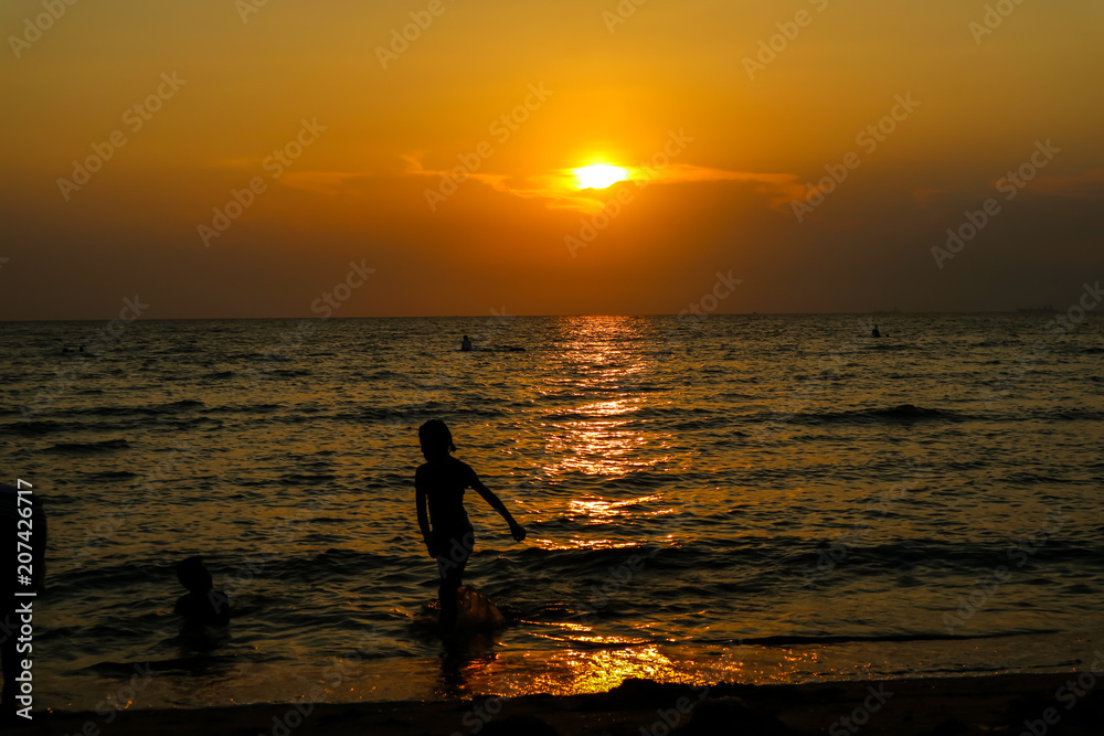 silhouette woman run from sea to beach and sunset