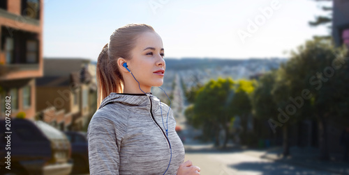 Photography fitness, sport and technology concept - happy woman running and listening to mus