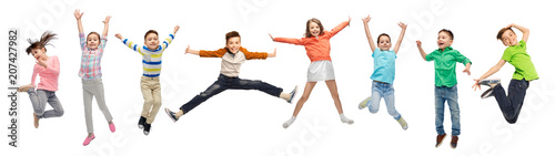 happiness, childhood, freedom, movement and people concept - happy kids jumping in air over white background photo