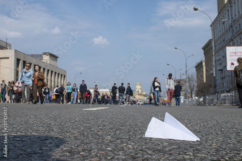 Moscow, Russia - April 30, 2018: A small paper aircraft on asphalt. Airplane is logo of the Telegram app. Sending message concept. Durov's Telegram is banned in Russia.