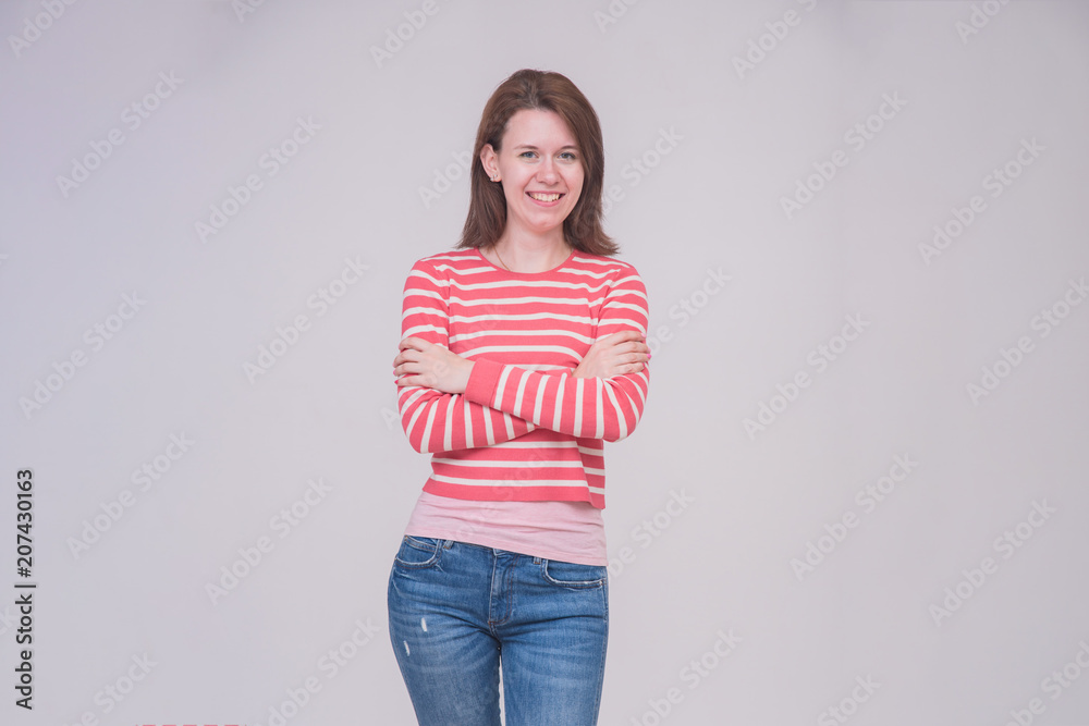 portrait of a beautiful brunette girl in jeans on a white background in different poses with different emotions. portrait of a beautiful brunette girl in jeans on a white background in different poses with different emotions.