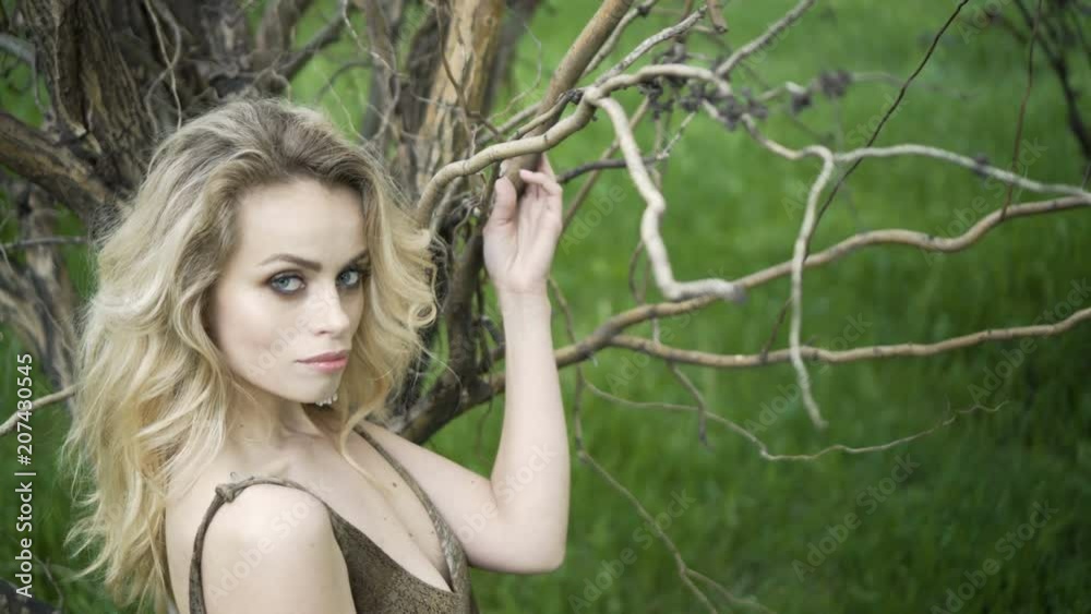 Close up portrait of beautiful young woman hand through hair blowing in wind forest Close up portrait of beautiful young woman hand through hair blowing in wind forest
