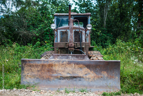 Old abandoned rusty tractor in the Carpathian mountains  Ukraine. Concept of nature meeting technology.