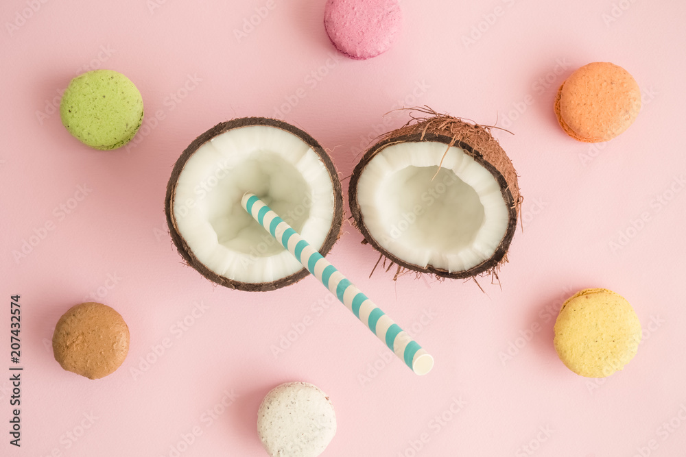 Fototapeta premium Coconut with macaron cookies against rose background abstract.