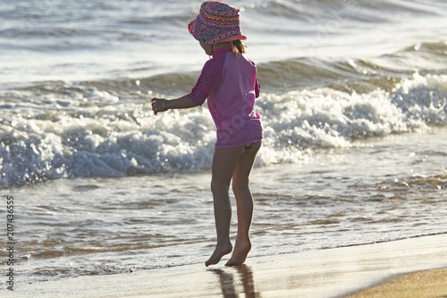 infante niña en la playa y el mar Fototapeta