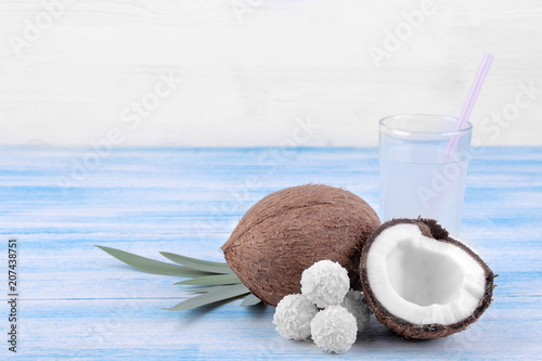 Coconut with coconut sweets and coconut milk on a blue wooden background