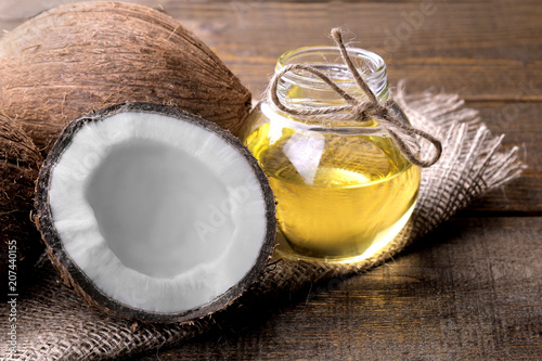 Cuadro en lienzo Coconut with coconut oil on a brown wooden background