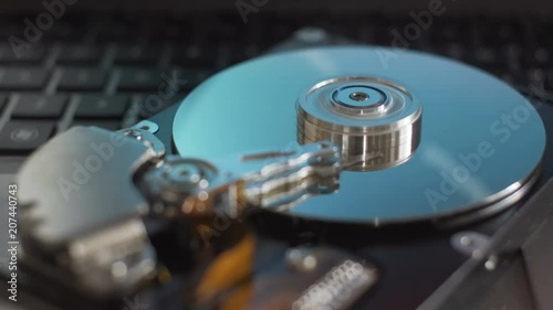 Cinemagraph. Working process of disassembled hard drive. Blue reflections on plates. photo