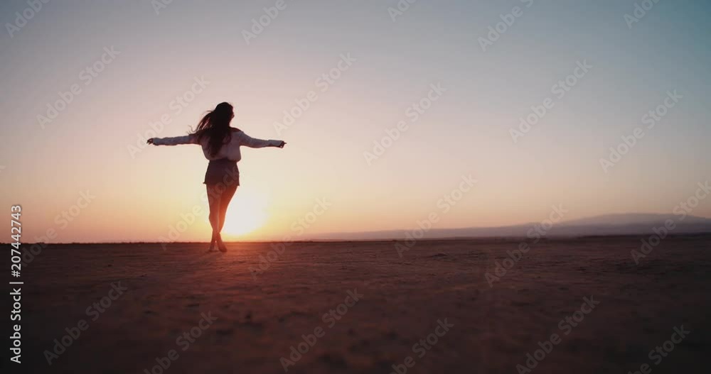 Young woman on holidays walking barefoot in desert at sunset Young woman on holidays walking barefoot in desert at sunset