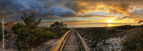Boardwalk over dunes at beach at sunset 