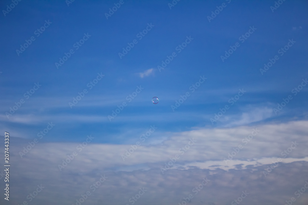 Small bubble flying on blue sky with clouds Small bubble flying on blue sky with clouds