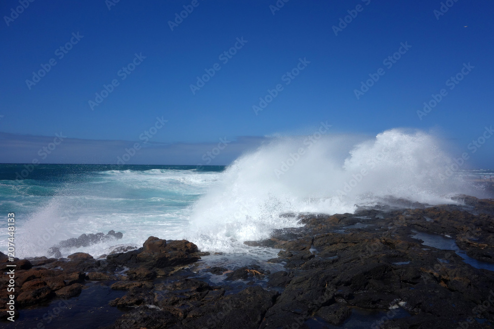 Welle bricht auf Felsen