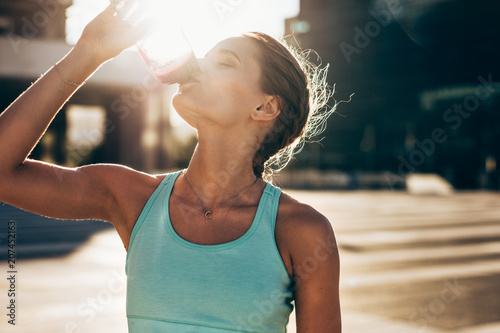 Woman drinking water after workout session
