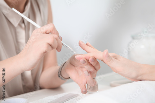 Manicure treatment at nail salon. Applying Nail Polish. Close up of women Hands