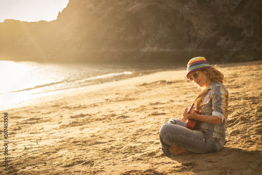 Guitar Playing Girl Beach Relaxation Song Music Concept. lonely happy and free woman with blonde hair enjoy vacation and lifestyle with golden sunset backgroud