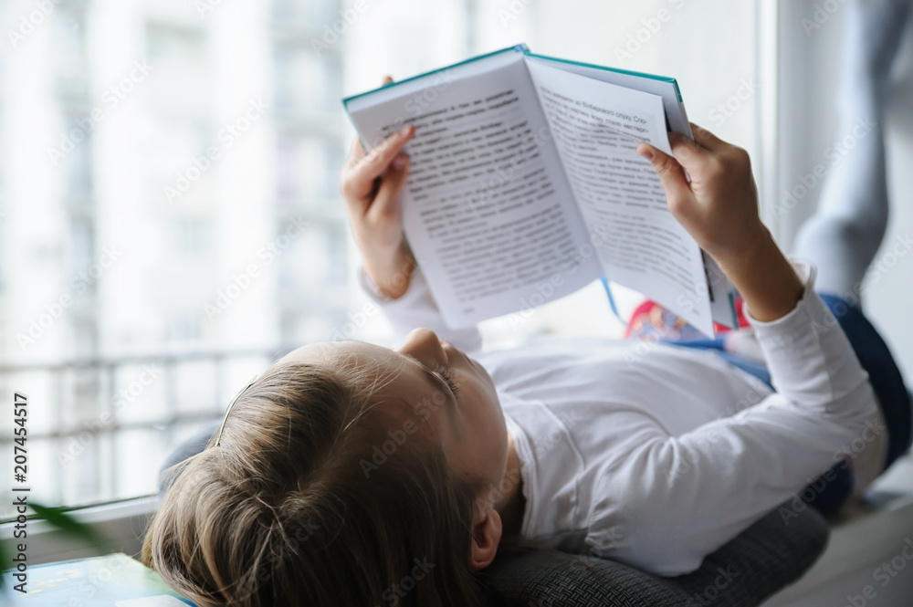 Naklejka premium The girl is reading a book.