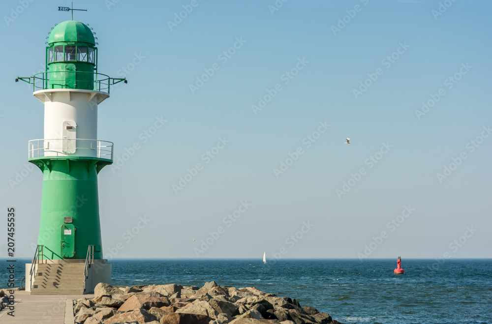 Grün weißer Leuchtturm an der Hafeneinfahrt in Warnemünde