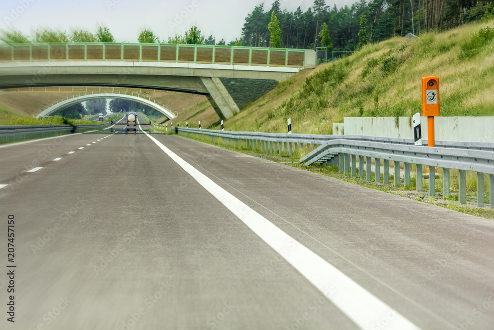 Neuer Autobahnabschnitt mit Notrufsäule und Grünbrücke