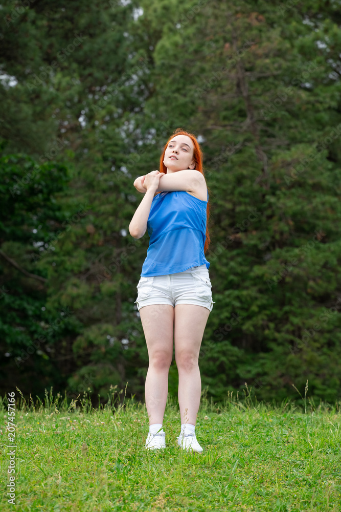 a girl is  doing sports exercises in the park