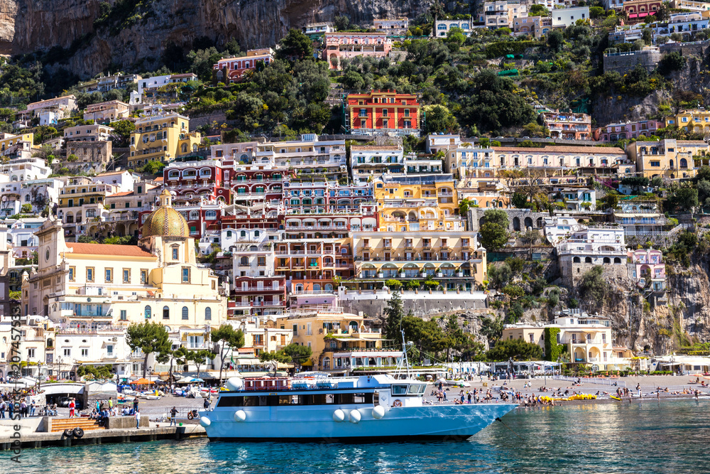 View from the sea to the Italian city with colorful houses on the mountains. Amalfi Coast - architectural and travel background
