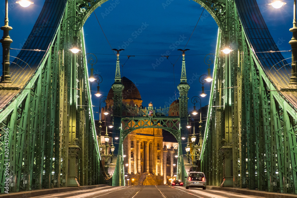 Naklejka premium ars and tram on a Liberty bridge (Szabadsag hid) at night in Budapest,Hungary.