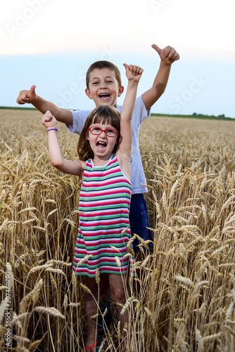 Happy beautiful girl and boy in wheat field autumn.