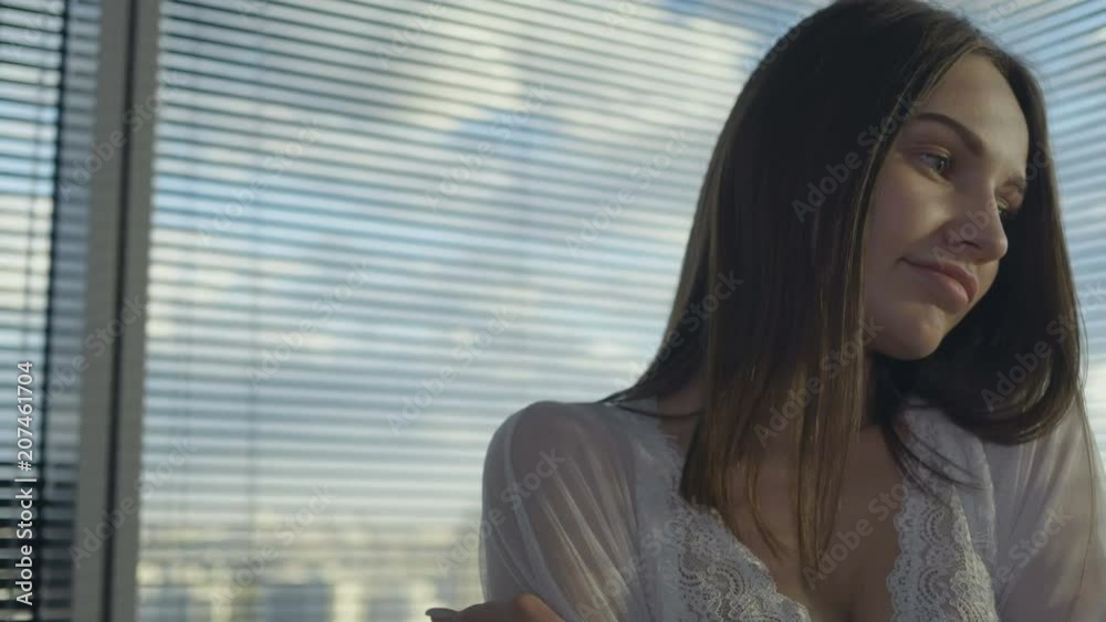 Lovely girl is standing next to the window Lovely girl is standing next to the window