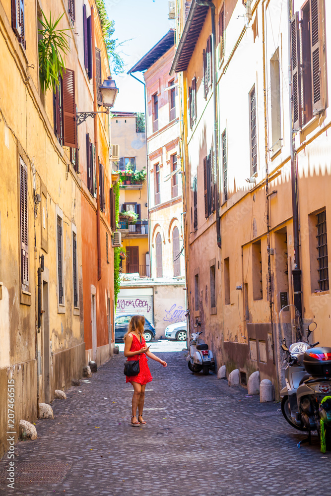 Girl in red dress walking on Rome street. Trastevere, Rome, Italy. Young girl. Old street in Rome. Pretty girl around the corner. Rome architecture