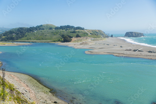 Rocks and beach of Russian River empying into Pacific Ocean at Jenner, California photo