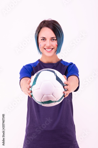 Portrait d'une jeune supportrice de l'équipe de France de football tenant un ballon dans ses mains