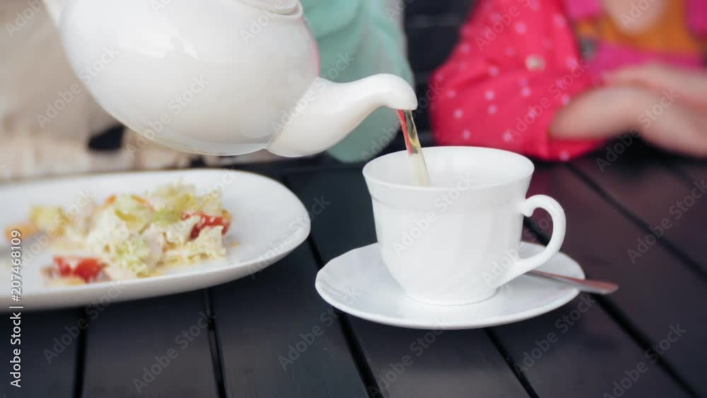 Mother and daughter eat and drink in cafe outside Mother and daughter eat and drink in cafe outside
