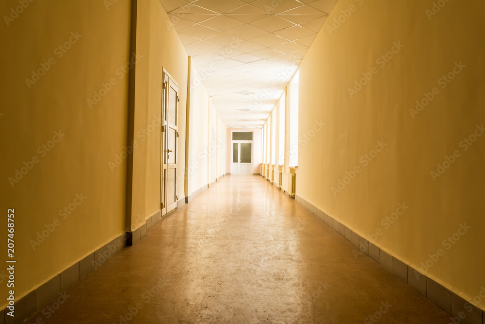 long dark corridor with bright light from windows, light at the end of corridor