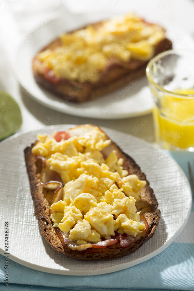 Sourdough bread slices with fried bacon and scrambled eggs Sourdough bread slices with fried bacon and scrambled eggs