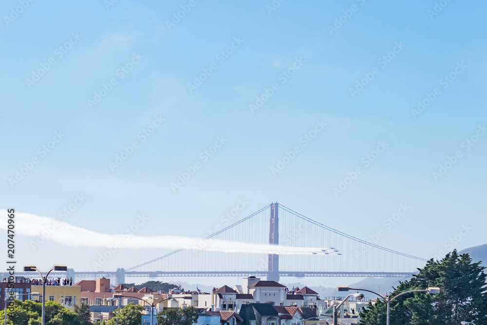 Fototapeta premium Fighter jets in formation with golden gate bridge in the background - space for title on top