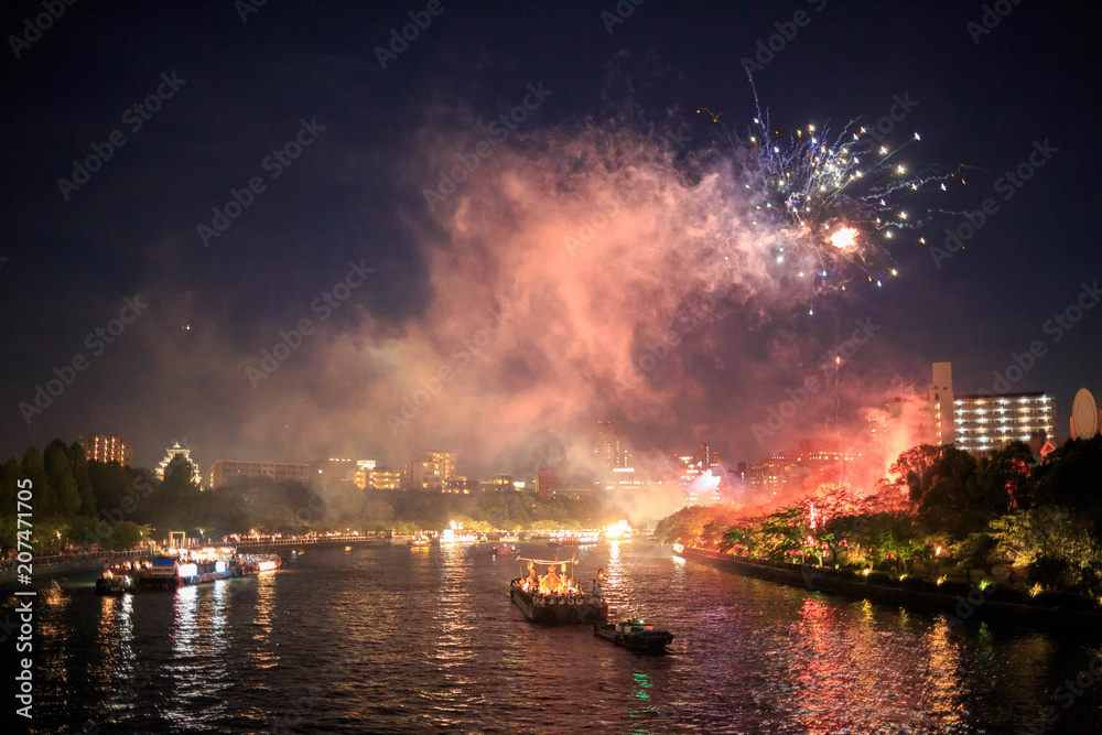 Osaka, Japan - July 25, 2015: Boats cruise up the O River during a fireworks display at the Tenjin Matsuri Summer Festival