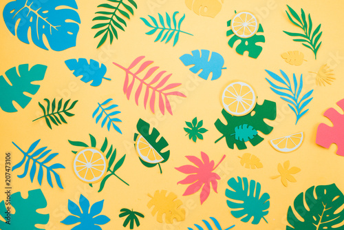 Tropical leaves pattern. Blue, green and pink leaves on a bright yellow background. Summer vacation concept.