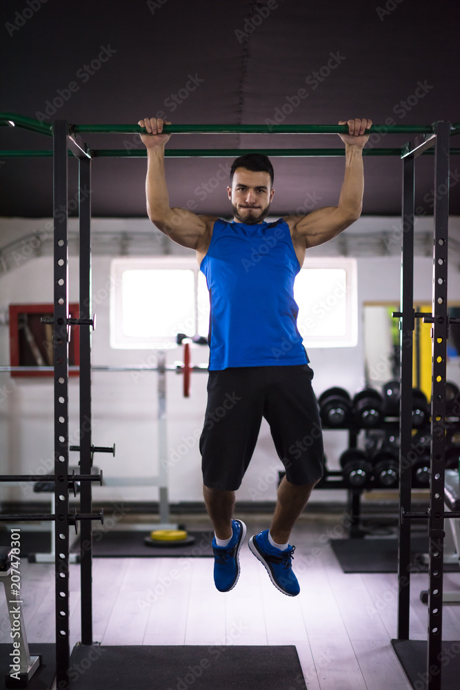 Fototapeta premium man doing pull ups on the horizontal bar