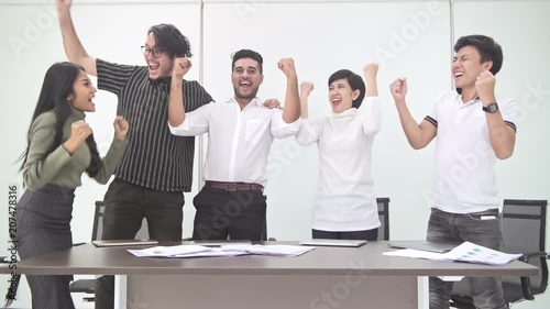 Business meeting. Small start up business meeting in room. Asian team with indian man finishes their meeting, close laptop and cheering. New business model start up concepts.