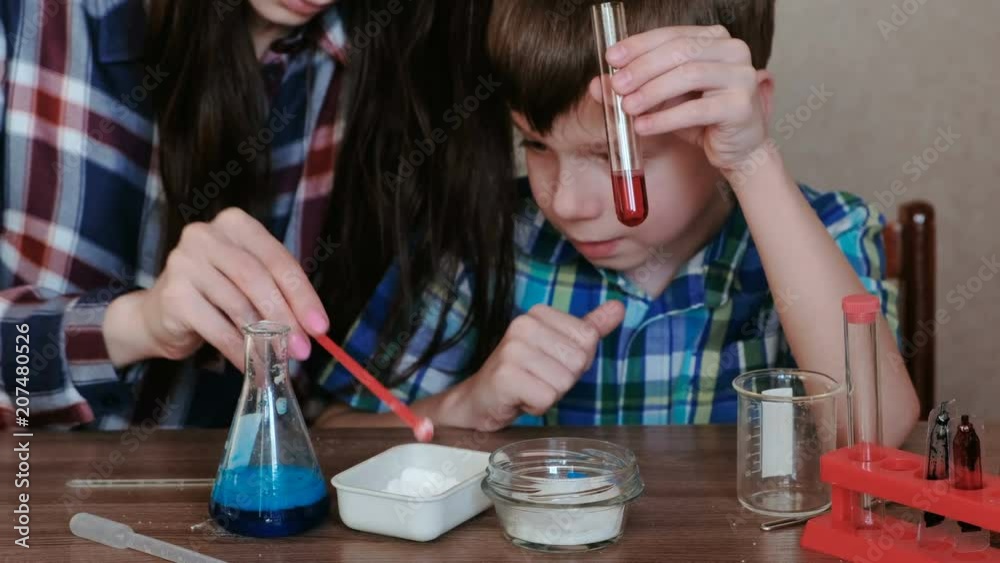 Chemistry experiments at home. Mom and son make a chemical reaction