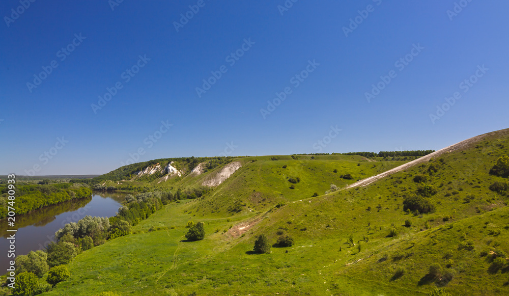 Landscape in the valley of the Don River in central Russia. Top view of the spring coastal forest, hill and pond.