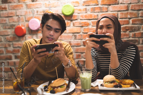 muslim couple playing mobile games