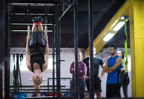 woman working out with personal trainer on gymnastic rings