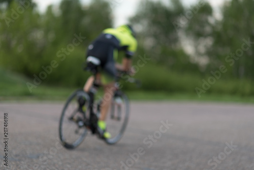 Cyclist in maximum effort in an asphalt road outdoors. Blured picture for the background